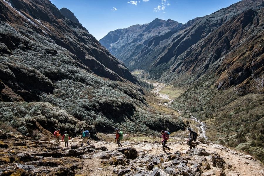 Trekkers descending a high rocky valley