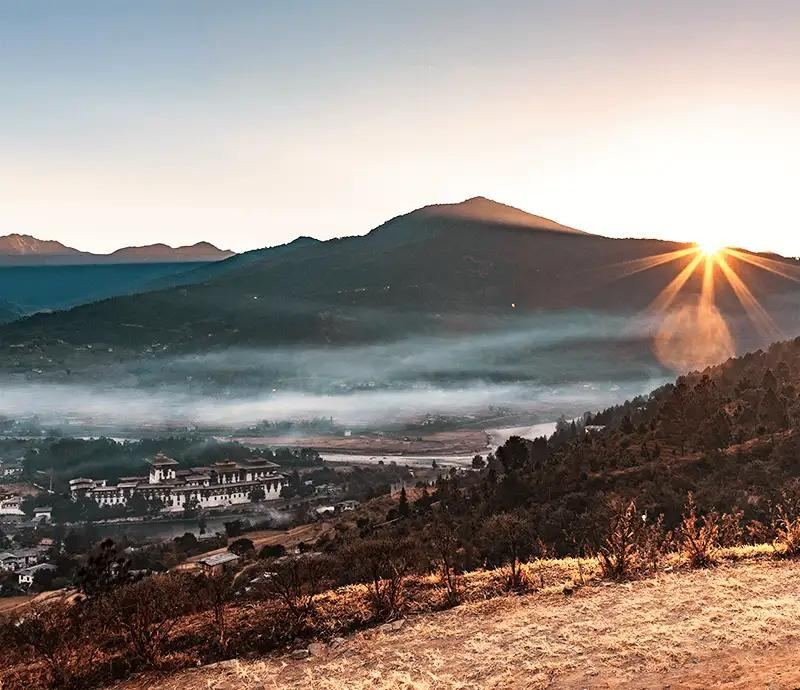 Sunrise over a misty Bhutanese valley