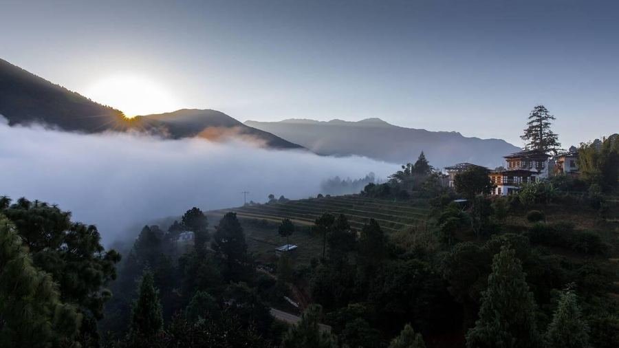 Dawn light over forested Himalayan ridges