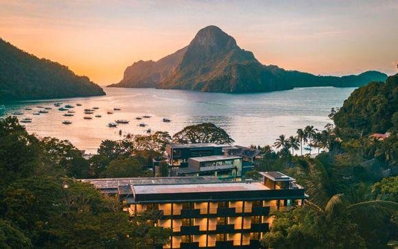 Resort overlooking a Palawan bay at sunset with limestone karsts beyond