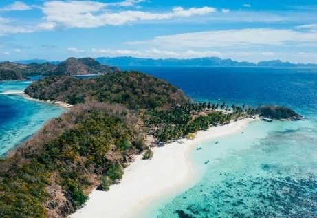 Aerial view of a white sand island beach with turquoise shallows