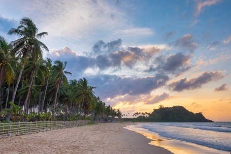 Palm-lined shoreline at sunset on the El Nido mainland