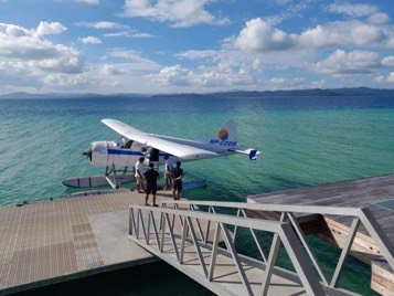 Seaplane moored at a jetty with guests boarding