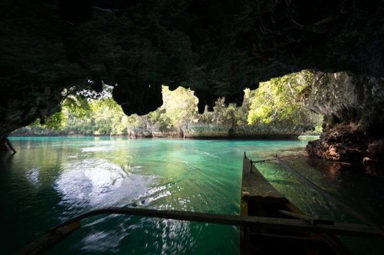 Boat passing through a sea cave entrance at Sohoton Cove