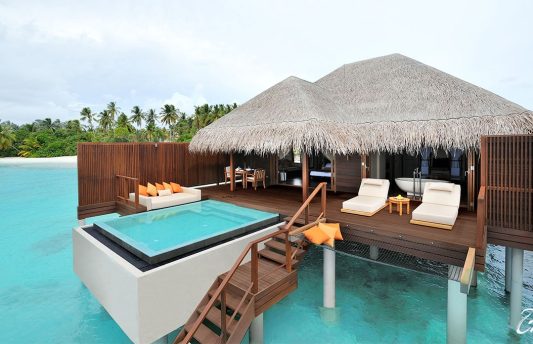 Exterior view of an Ocean Villa at Ayada Maldives in Gaafu Dhaalu Atoll, featuring thatched roof, private infinity pool, wooden sun deck, and panoramic views of the turquoise Indian Ocean.